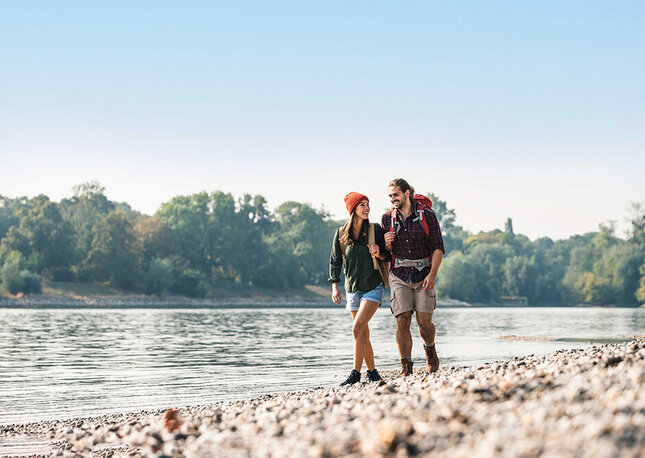 Ein Paar, das am Ufer eines Flusses in Nordhessen wandert.