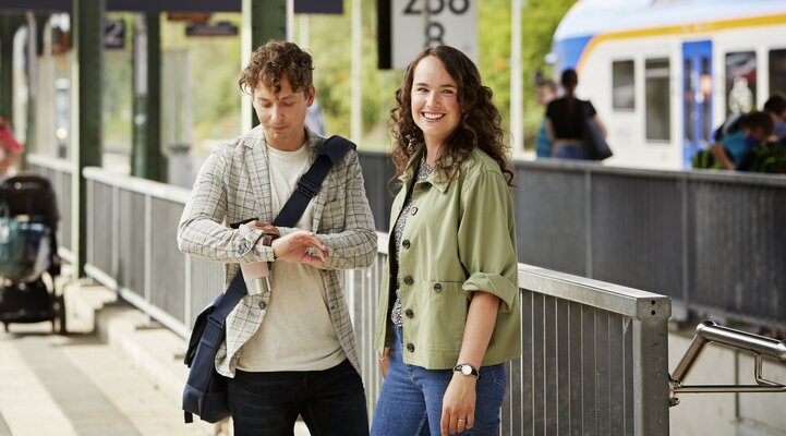 Eine Frau und ein Mann stehen an einem Bahnsteig