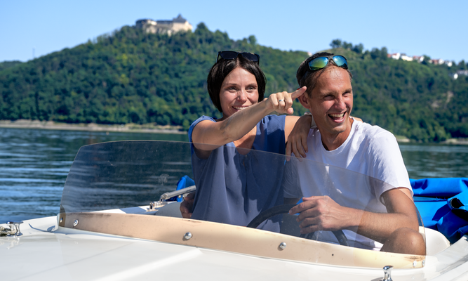 Ein Mann und eine Frau in einem Motorboot auf einem See.